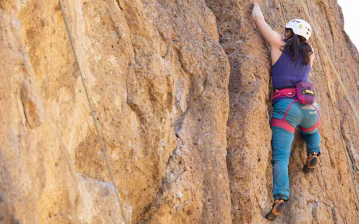 woman reaches while rock climbing on outward bound course for women in the pacific northwest 